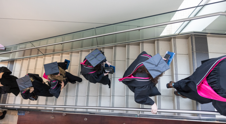 Students walking up the stairs to graduation