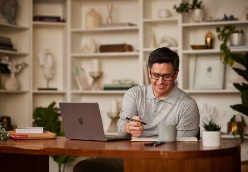 Man sitting at desk looking at laptop